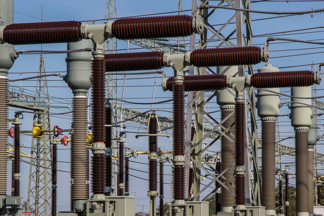 Services Detailed view of high voltage electrical substation with transformers and power lines.