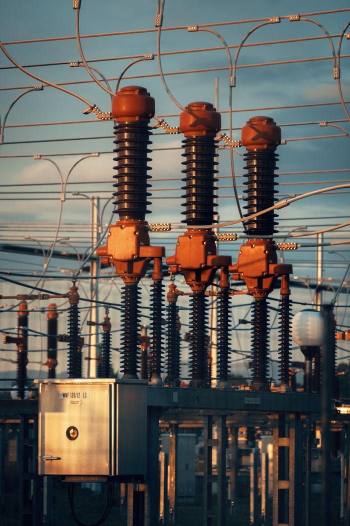 About Close-up of high voltage transformers at a power station in Austria during daylight.